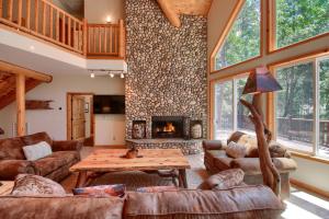 a living room with a stone wall and a fireplace at Rivercrest Lodge -Hot Tub -Pool Table -Firepit in Wawona