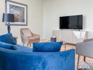 リヤドにあるGR-Luxurious 1-Bdr with Fendi Furniture in Damacのリビングルーム(青いソファ、テレビ付)