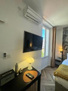 een kamer met een bed en een tafel met een tv bij PALAIS DES FESTIVALS à 3 min - Croisette - Plage in Cannes