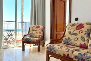 a living room with a couch and a chair and a balcony at Hotel Don Ignacio in San José