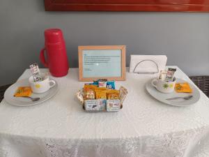 a table with two plates of food and two cups at Sol e Mar Sandrady in Praia Grande