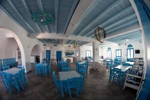 un comedor con sillas y mesas azules en Viva Mare Foinikounta, en Finikounta