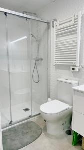 a white bathroom with a shower and a toilet at Apartamento con parking en Torre Almenara in Punta Umbría