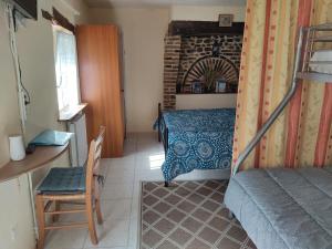 a bedroom with a bed and a desk and a chair at PETIT MAS COSY DU BORD DE LOIRE a 15 MM DU PARC LE PAL in Diou
