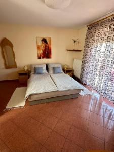 1 dormitorio con cama y ventana grande en Judit Apartments, en Hévíz