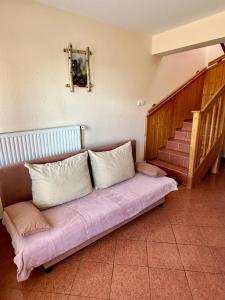 een bank met kussens in een kamer met een trap bij Judit Apartments in Hévíz