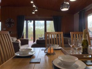 a dining room with a wooden table with a bottle of wine at Heron lodge in Tattershall