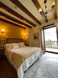 - une chambre avec un grand lit et une fenêtre dans l'établissement Posada San Pelayo, à Camaleño