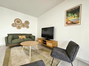 圖盧茲的住宿－Superbe Apt 2 ch, terrasse, WIFI, parking gratuit，带沙发和电视的客厅