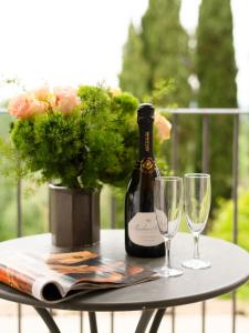 una botella de vino sentada en una mesa con dos copas en Cappuccina Country Resort en San Gimignano