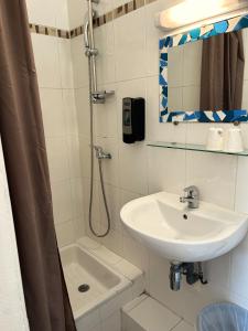 a bathroom with a sink and a shower at Hôtel Le Bon Accueil in Porto Ota