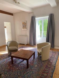 a living room with two chairs and a coffee table at Appartements de la ferme du Brocey in Crolles +9 photos