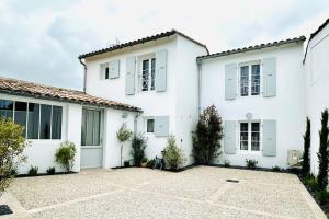 ラ・フロットにあるLa Villa des Matelotsの白窓と私道のある白い家