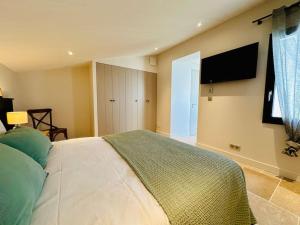 Schlafzimmer mit einem Bett und einem Flachbild-TV in der Unterkunft La Villa des Matelots in La Flotte