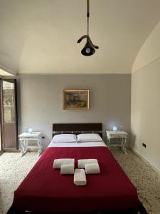 a bedroom with a large red bed with two white towels at Il Castello di Atessa in Atessa