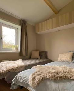 two beds in a room with a window at Chalet Wijd Weg in Rendeux