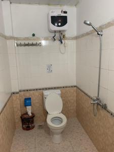 a bathroom with a toilet and a tv on the wall at Kalina Asian Dormitory in Mumbai
