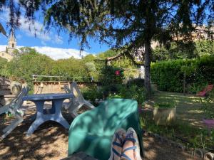 a persons feet sitting on a chair next to a picnic table at La roseraie Bonnieux in Bonnieux