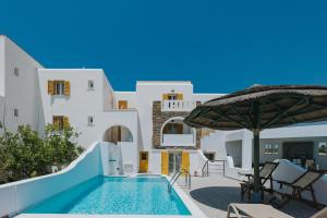uma piscina com um guarda-sol ao lado de uma casa em Aegean Palace em Plaka