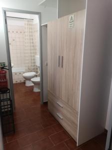 baño con aseo y un gran armario de madera. en Panorama Apartament, en Portimão