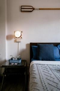 1 dormitorio con 1 cama y 1 mesa con lámpara en Island Lyfe Adventures en El Nido