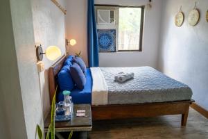 a small bedroom with a bed with blue pillows at Island Lyfe Adventures in El Nido