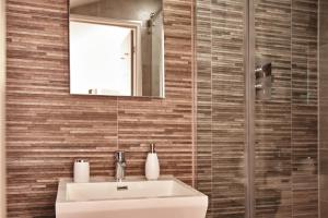 a bathroom with a sink and a mirror at The Moorings - Duplex apartment on Torquay Marina with Hot Tub in Torquay