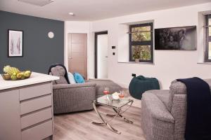 a living room with two couches and a table at Harbour Breeze - On Torquay's iconic marina with hot tub in Torquay