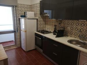 una pequeña cocina con fregadero y nevera. en Panorama Apartament, en Portimão