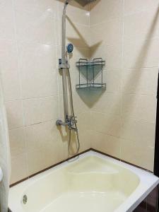 La salle de bains est pourvue d'une douche et d'une baignoire. dans l'établissement ObodHotel, à Douchanbé