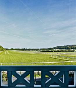 a view of a green field from a fence at Pegase in Deauville