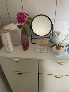 a shelf with a vase with a flower and towels at Ferienwohnung mit WINTERGARTEN in Bahnhofsnähe in Eystrup