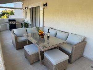 a table and chairs on a patio with a table and some fruit at Vouliagmeni Seaside Escape in Athens