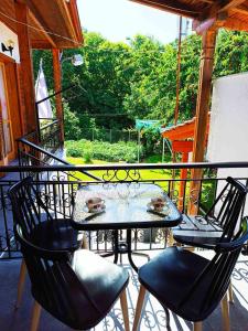 een balkon met een tafel en stoelen op een veranda bij Τα πλατάνια 