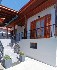 uma casa branca com escadas e uma varanda em Τα πλατάνια 