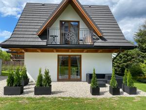 a house with a balcony on top of it at RELAS - przytulny domek z dwoma sypialniami i antresolą oraz JACUZZI in Murzasichle
