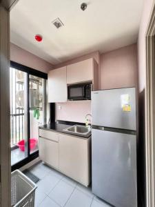 a kitchen with a refrigerator and a sink at ห้องพักระยะสั้นรายเดือนวิวติดแม่น้ำ ชั้น 30 ราคาถูก in Ban Sai Ma