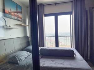 a bedroom with a bed and a large window at ห้องพักระยะสั้นรายเดือนวิวติดแม่น้ำ ชั้น 30 ราคาถูก in Ban Sai Ma