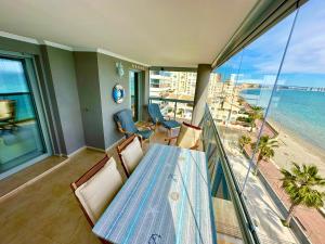 Un balcón con mesa y sillas y el mar. en Beach Apartment La Manga, en La Manga del Mar Menor