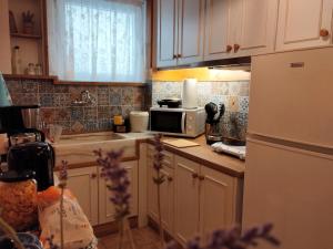 a kitchen with white cabinets and a microwave oven at Something About Mary in Athens