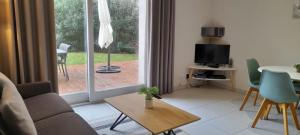 a living room with a couch and a table and a television at L'ETOILE DE MER in Sète