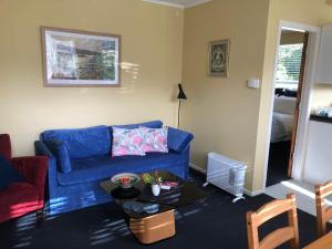 sala de estar con sofá azul y mesa en Close To Nature & City en Wellington