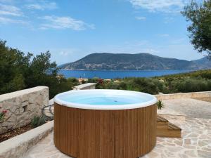 a large wooden tub sitting on a patio with a view of the ocean at Villa Sasà in Fiskardo
