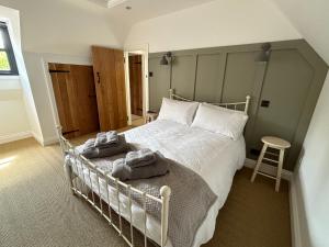 a bedroom with a white bed with towels on it at Bee Cottage - Romsey in Romsey