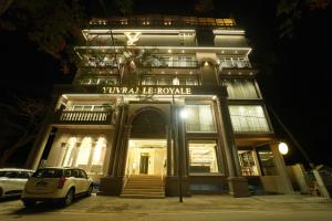 a white car parked in front of a building at night at Yuvraj Le: Royale in Mysore
