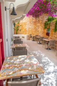 una stanza con tavoli e sedie e un muro con fiori di Hotel Begonvil a Kaş