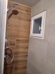 a shower in a bathroom with a wooden wall at Duplex lumineux - 40m2 - 2 chambres - Balcon terrasse - Parking - Entierement renové en Mai 2024 in Cauterets