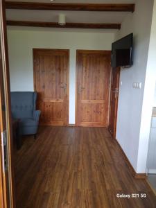 a living room with wooden doors and a couch at Domek letniskowy w Karwiku in Karwik