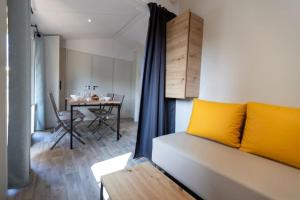 Habitación con cama y comedor con mesa. en Camping Le Damier en Pianottoli-Caldarello