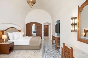 um quarto de hotel com uma cama e uma televisão em Movenpick Resort Sharm El Sheikh em Sharm el Sheikh